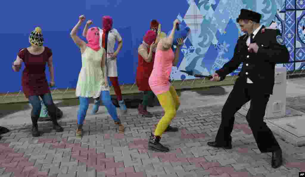 A Cossack militiaman attacks Nadezhda Tolokonnikova as she and fellow members of the punk group Pussy Riot, including Maria Alyokhina (center, in the pink balaclava), stage a protest performance in Sochi, Russia, on February 19.