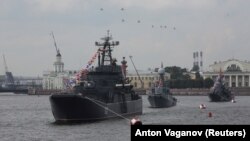 Руски военни хеликоптери летят над военноморски кораби на Балтийския флот в река Нева по време на репетиция за парада за Деня на военноморските сили в Санкт Петербург, Русия. Архивна снимка от 28 юли 2017 г.