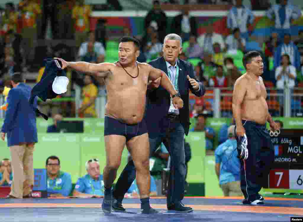 Things got ugly and rather comical when two Mongolian wrestling coaches stripped off their clothes to protest a referee's decision to penalize Mandakhnaran Ganzorig as he celebrated a sure victory late in his match against Uzbek wrestler Ikhtiyor Navruzov. The Uzbek ended up winning when the Mongolian team lost its appeal, giving Navruzov an additional point.