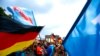 Hrvatski istražitelji su njemačke kolege obavijestili da Alexander R. u Hrvatskoj nabavlja oružje i pritom govori da je oružje, , „namijenjeno AfD-u, jednoj desničarskoj stranci“, što su iz AfD demantovali (na fotografiji antiimigrantski protesti AfD u Berlinu 2018. godine)