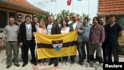 Vit Jedlicka (center) poses with the Liberland flag and future citizens in a Serbian village in 2015.