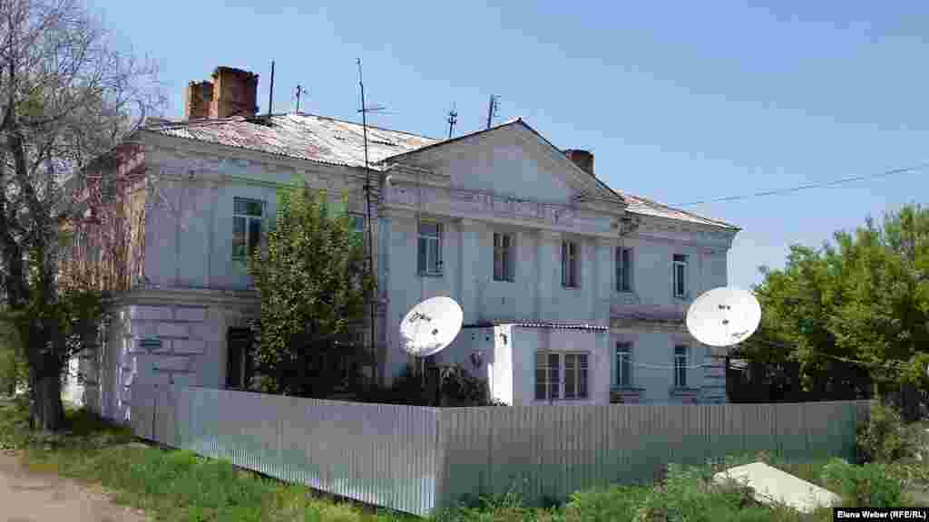 В этом двухэтажном доме во времена сталинских репрессий проживали офицеры Карлага – старший офицерский состав. Теперь здесь живет несколько семей. Снаружи, со стороны музея, этот восьмиквартирный дом смотрится более или менее ухоженно. Внутри ремонт дома оставляет желать лучшего и крыша протекает, говорят жильцы. Здесь высокие потолки, просторные комнаты, но очень маленькая и узкая кухня. Жители пользуются водой из скважины, квартиры отапливаются печками, еду в основном готовят на газовой плите, летом в доме очень холодно. Внутри дом очень старенький, сохранились даже деревянные лестницы.