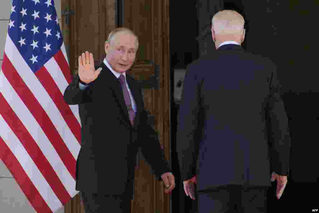 Putin waves before entering the villa with Biden (right). 