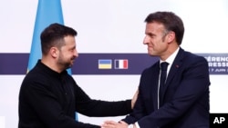 Президент Франції Еммануель Макрон (праворуч) тисне руку президенту України Володимиру Зеленському під час спільної прес-конференції. Париж, 7 червня 2024 року
