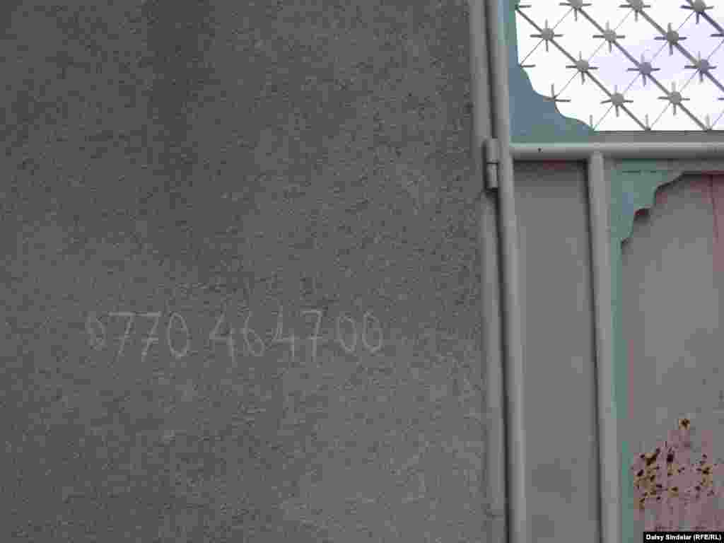 Many homes in Osh neighborhoods still bear scrawled telephone numbers -- a remnant of the days and months after the June 2010 clashes, when residents left telephone numbers where relatives and aid agencies could reach them. Here, an Uzbek home in the neighborhood of Cheremushki, which saw some of the worst violence.
