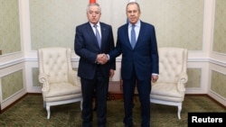 Russia's Foreign Minister Sergei Lavrov (right) shakes hands with Tajikistan's Foreign Minister Sirojiddin Muhriddin as they meet on the sidelines of a CIS conference in Minsk on April 12.