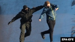 A Belarusian police officer detains a protester in Minsk on January 23. Crowd numbers have dwindled as protesters face violent tactics and harsh sentences.