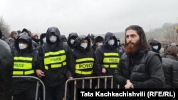 აქციის მონაწილე პოლიციის კორდონთან. გუმათი 