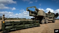 Soldații se pregătesc să încarce un sistem de rachete tactice (ATACMS) pe un sistem de rachete de artilerie de mare mobilitate (HIMARS). (fotografie de arhivă)