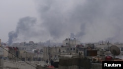 Smoke rises from the suburb of Erbeen in Damascus during fighting earlier this year. Activists say more than 8,000 Syrians have been killed in the government's crackdown against dissent.