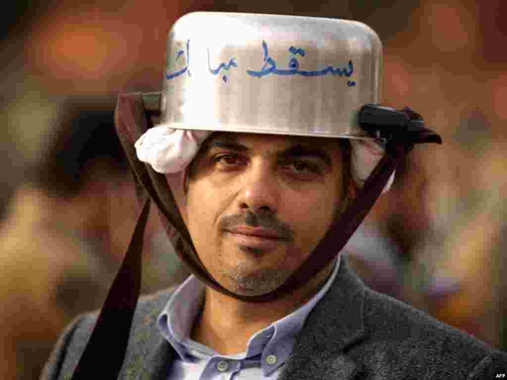 An antigovernment demonstrator protects his head with a kitchen pot at a barricade on Tahrir Square on February 4.