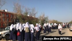 Казакстанда мектептин алдында акцияга чогулган жоолук салынган мектеп окуучулары. 5-сентябрь, 2018-жыл.