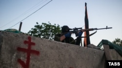 A pro-Russian sniper aims his rifle at a checkpoint near Slovyansk 