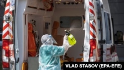 Medicinski radnik dezinficira vozilo hitne pomoći