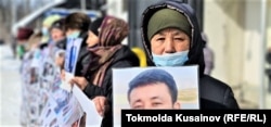 Заватхан Турсун аттуу казак аял Кытайдын ШУАРында абакта жаткан уулу Баймурат Наврузбек уулунун бошотулушун талап кылып, кытайлык консулдуктун кеңсесинин маңдайына пикетке чыкты. Алматы шаары, Казакстан. 2021-жылдын 26-февралы.
