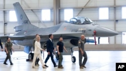 Ukrainian President Volodymyr Zelenskiy (second right) and Dutch Prime Minister Mark Rutte (center) inspect F-16 fighter jets in Eindhoven, Netherlands, on August 20.