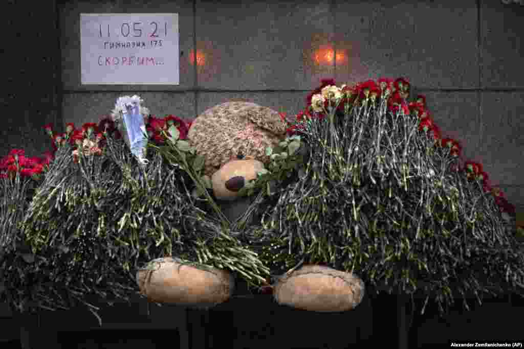 A teddy bear and flowers with the poster reading "11.05.21, School # 175, Mourn" in memory of the slain students in Kazan at the Tatarstan region's office in Moscow.