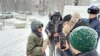 Активистка Акторгын Аккенжебаласы разговаривает с представителям власти, который прерывает ее пикет в Алматы. 22 января 2025 года