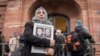Сирийката Ясмин ал-Машан държи снимки на своите братя пред съда в Кобленц. Четирима от тях са жертви на сирийския режим.
