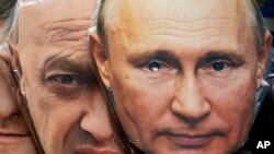 Санкт-Петербургдагы зер дүкөнүнүн терезесиндеги Орусиянын президенти Владимир Путиндин (оңдо) жана "Вагнер" тобунун жетекчиси Евгений Пригожиндин сүрөттөрү түшүрүлгөн бет каптар. 2023-жыл, 4-июнь 