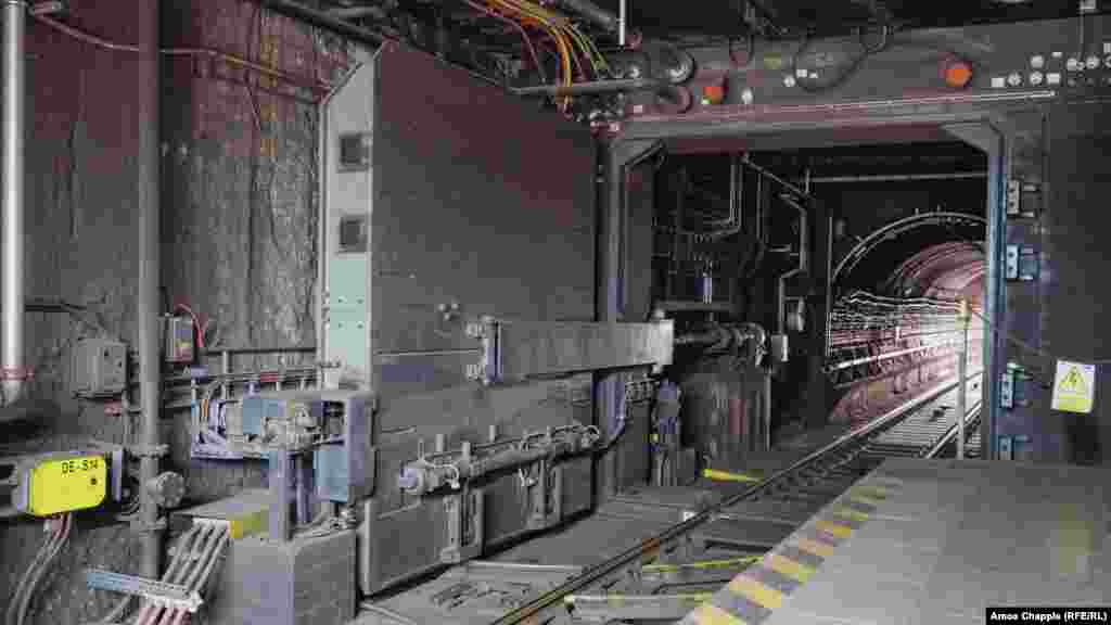Blindirana vrata unutar metro stanice Dejvicka u Pragu fotografisana u momentu dok se približava voz metroa. Većina OSM-a izgrađena je tokom Hladnog rata, ali ažurirane verzije sistema iz sovjetskog doba ugrađene su u neke novije stanice podzemne željeznice koje je izgradila nezavisna Češka. 