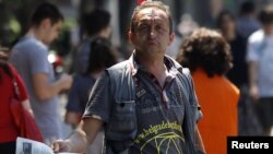 Ulični prodavac dnevnih novina sa naslovnicom o Ratku Mladiću