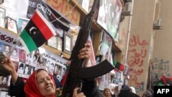 A woman fires a weapon in the air as people gather to celebrate the UN resolution in the eastern rebel-held city of Benghazi today.