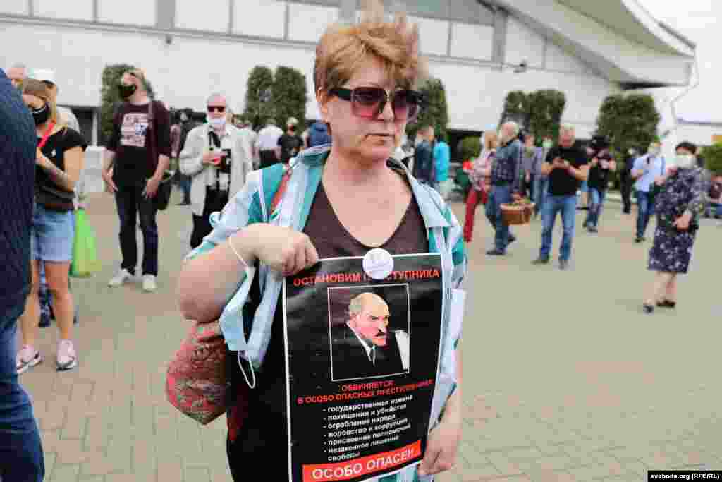 A protester at the June 7 rally in Minsk holds a portrait of Belarusian President Alyaksandr Lukashenka with a sign reading: "Stop the criminal man." 
