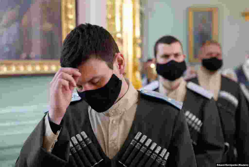 Cossacks wearing protective face masks pray during a service in Stavropol, Russia, on the eve of Orthodox Easter.