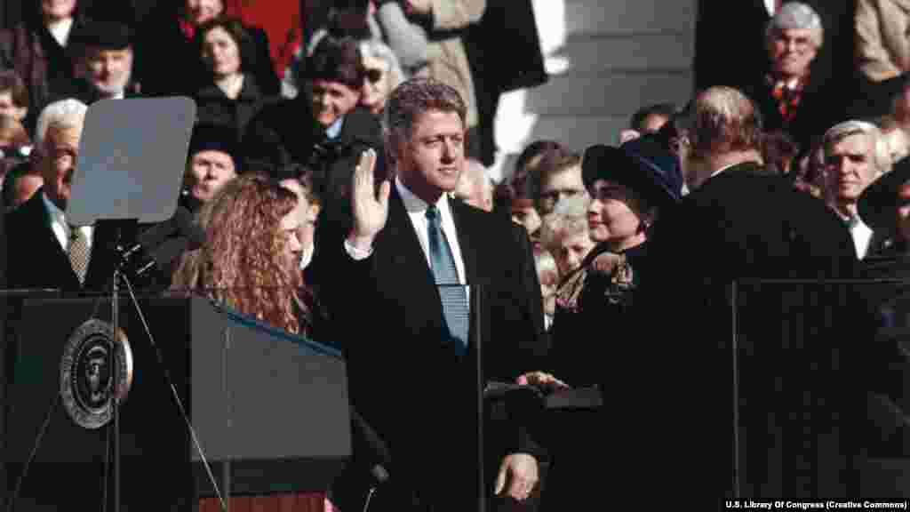 Bill Clinton polaže zakletvu pored svoje supruge Hillary i kćerke Chelsea 20. januara 1993. godine. Clinton će služiti dva mandata. Dolazeći predsjednici moraju se zakleti da će "vjerno izvršavati dužnost predsjednika" i "čuvati, štititi i braniti ustav Sjedinjenih Američkih Država". 