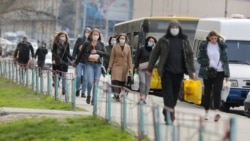 Люди у медичних масках йдуть вулицею в районі Оболонь, Київ, 21 березня 2020 року