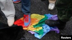 Protesters stand on a rainbow flag during a counterdemonstration outside the Russian parliament following the passing of anti-gay-rights legislation.