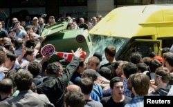 A crowd attacks a minibus carrying gay-rights activists during an International Day Against Homophobia and Transphobia rally in Tbilisi in May 2013.