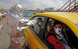Members of the Iranian Red Crescent test people with possible COVID-19 symptoms on a highway near Tehran.