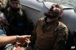 Un soldat ucrainean rănit, căruia i se administrează o injecție înainte de a fi evacuat de pe frontul de luptă din satul Șciurove, Ucraina, 25 septembrie 2022.