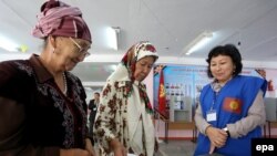 A woman votes at a polling station during Kyrgyz parliamentary elections in the village of Baitik, 25 kilometers from Bishkek.