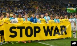 Гравці тримають банер із закликом зупинити війну