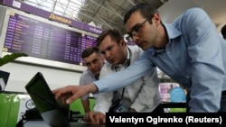 Technicians work on a flight timetable for Kyiv's main airport during a global cyberattack on June 27, 2017.