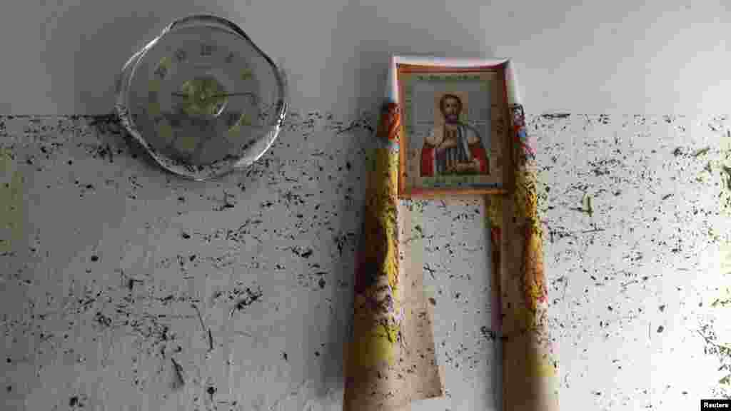 An icon hangs on the wall with dirt from the floodwaters marking it, in the town of Krymsk in the Krasnodar region.