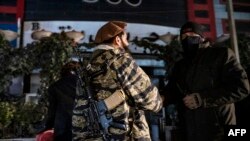 Afghan security personnel stand guard at the site of an alleged blast in the Dasht-e-Barchi neighborhood of Kabul on January 11.