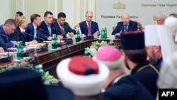 Acting Ukrainian President Oleksandr Turchynov (right) speaks, flanked by Prime Minister Arseniy Yatsenyuk (center), during the opening of roundtable talks on Ukraine's deepening crisis in Kyiv on May 14.
