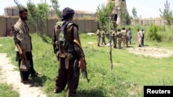 Afghan militias and policemen gather during a battle with Taliban militants in the Chardara district of Kunduz Province last month.