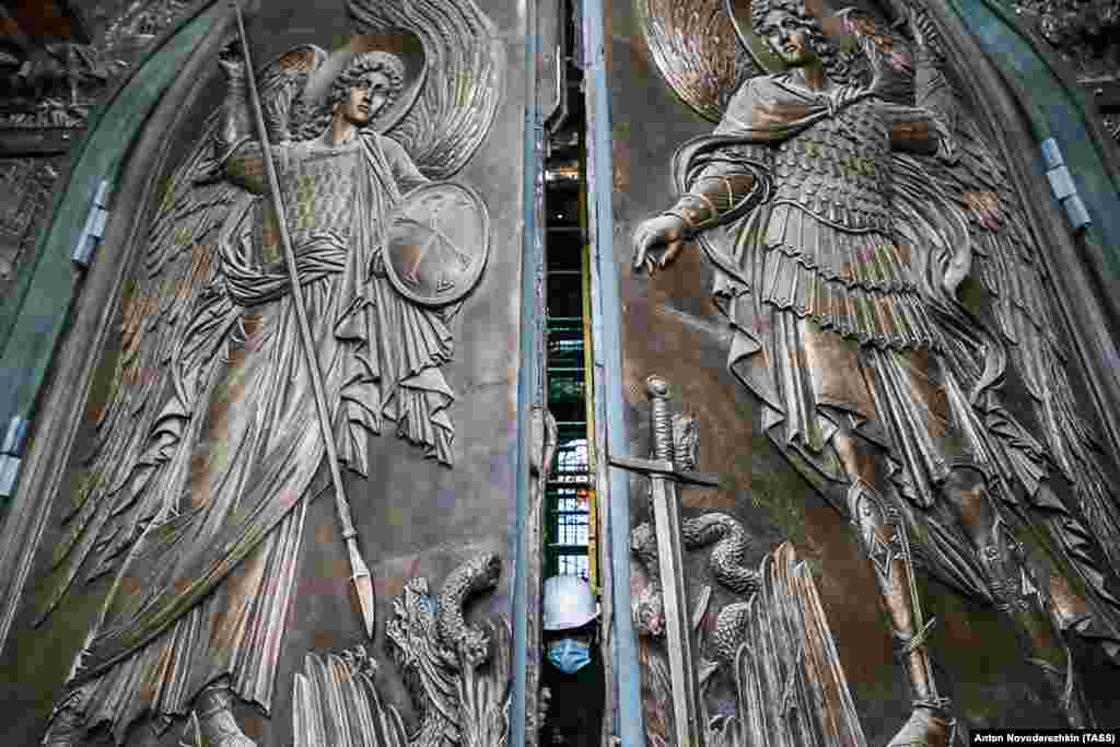A worker pushes open an entrance to the cathedral on April 27. 