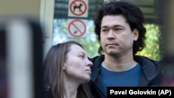 Dmitry Prokazov (right) and his wife, Olga, speak to press after a court session in Moscow on August 28.
