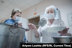 A hospital worker serves a hot meal.