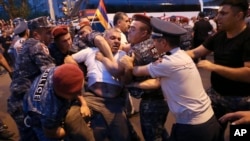 Police detain a demonstrator during an anti-government protest rally in Yerevan on June 3.