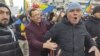 Un bărbat încearcă să liniștească un manifestant care huiduie o echipă de jurnaliști la protestul AUR, pe 12 ianuarie 2025.