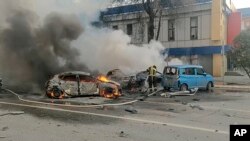 Кадр з відео, оприлюдненого телеграм-каналом МНС Росії в суботу, 30 грудня 2023 року, на якому пожежники гасять палаючі автомобілі після обстрілу в Бєлгороді, Росія