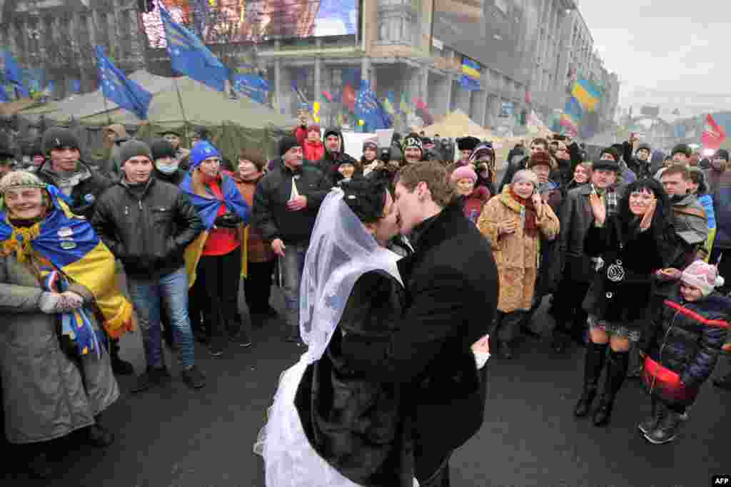 A newly wed couple kiss on Independence Square as pro-European protesters occupy Kyiv's central square, December 21, 2013.