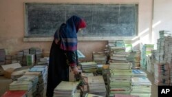 Оогандык мугалим Кабул шаарындагы мектепте китептерди чогултууда. Декабрь, 2022-жыл.